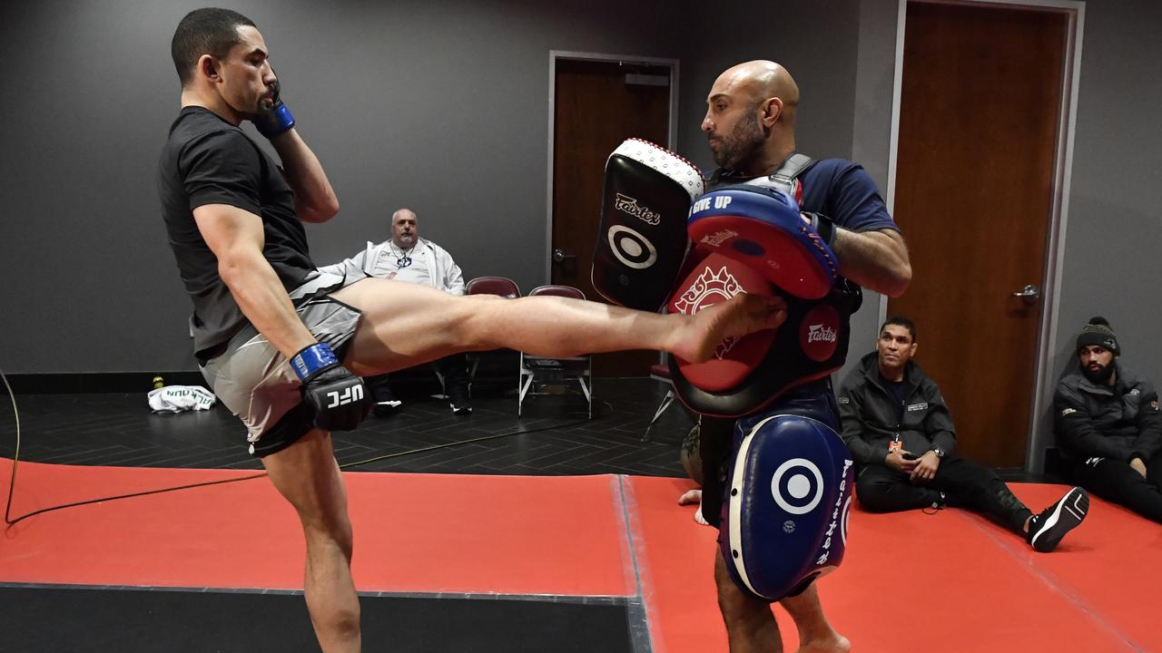 Malkoun (seated) wearing Panthers gear as Whittaker warms up in 2022. Picture - Mike Roach: Zuffa LLC